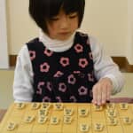 A girl is playing Shogi.